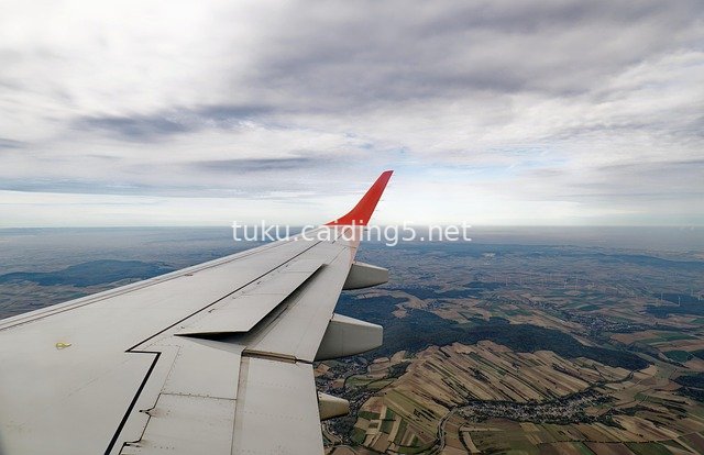 Aerial Shot of Airplane Wing with High-Altitude Overlook of Pastoral Cloud Sea Landscape