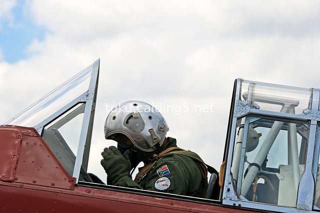 Harvard Pilot at South African Air Force Museum Prepares for Takeoff by Adjusting Oxygen Mask