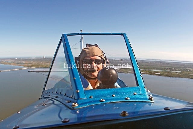 Open-Cockpit Pilot Piloting Aircraft Soaring Through the Sky