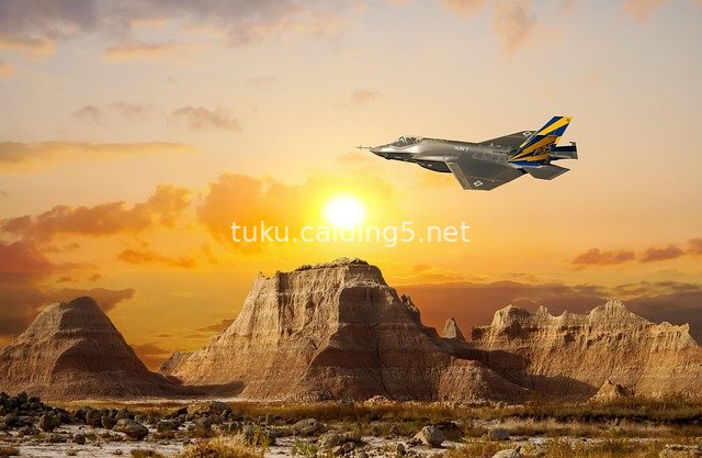Stunning Scene of a Fighter Jet Flying Over Desert Mountains at Sunset