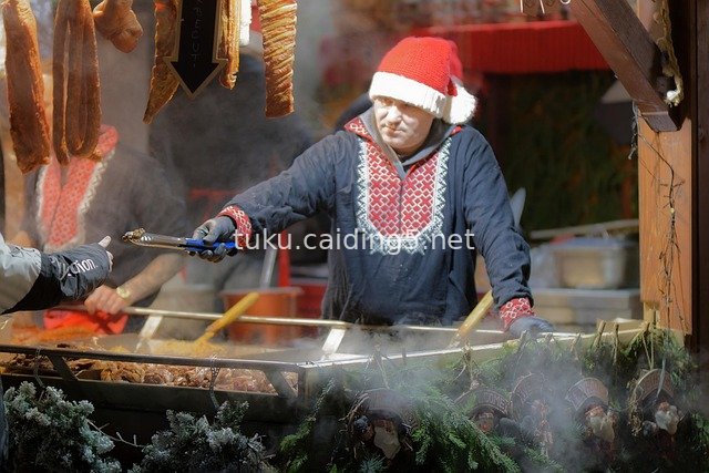 Outdoor Cooking at Christmas Market: Crafting Festive Dishes Amidst Warm Street Atmosphere