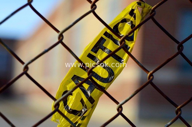 Yellow CAUTION Tape Wrapped Around Chain-Link Fence - Safety Warning Scene Material