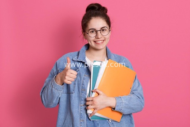 Smiling Student Holding Books and Giving a Thumbs-Up – Youthful Campus Learning & Education Scene