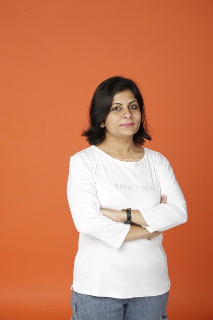 Professional Woman's Business Image | Confident Smile on Orange Background