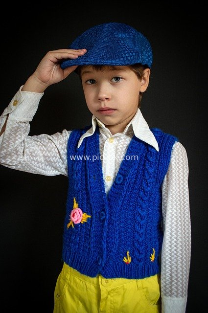 Fashion Portrait of a Cute Boy in Retro Knitted Vest and Hat