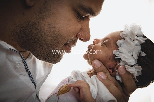 Father Gently Holding Newborn Baby Girl: A Warm Moment of Parent-Child Love