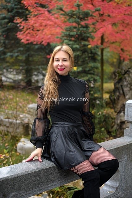Portrait of a Young Woman in Fashionable Attire at an Autumn Park