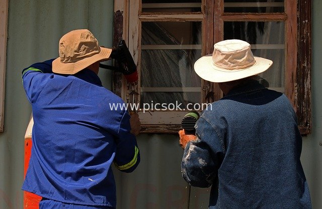 Two Workers Restoring an Old Building: Scene of Manual Paint Stripping