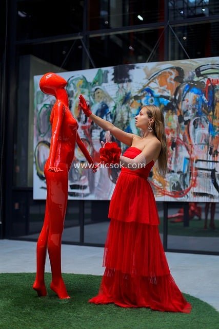 Art Gallery Scene with a Woman in a Red Dress and a Surreal Red Sculpture