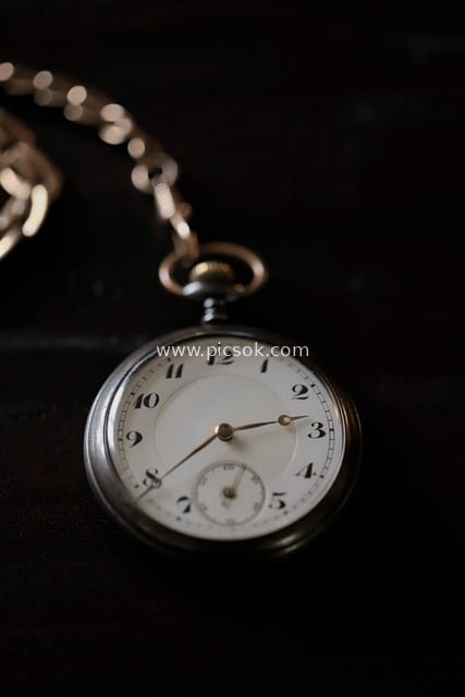 Close-Up of Vintage Pocket Watch with Metal Chain and Time Hands