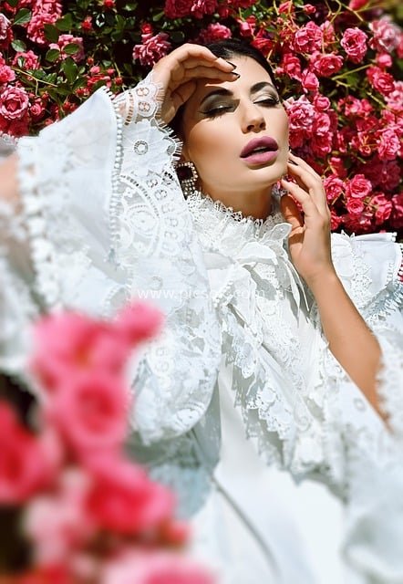 Portrait of a Woman in White Lace Gown Surrounded by Pink Blossoms