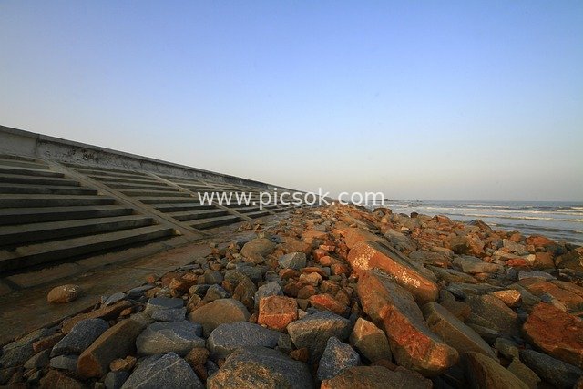 Coastal Rocky Beach Breakwater & Blue Sky Seaside Scenery