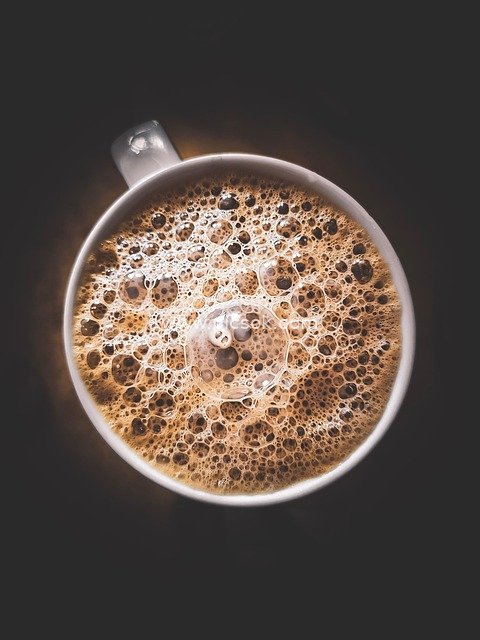 Close-up of Coffee Cup Foam Against Black Background - Rich Beverage Visual Presentation