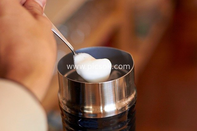 Hand Scooping Coffee Milk Foam: A Café Beverage Preparation Moment