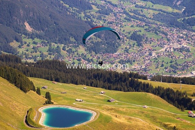 Paragliding in the Alps: Breathtaking Views of Heart-Shaped Lake, Meadows and Forested Slopes