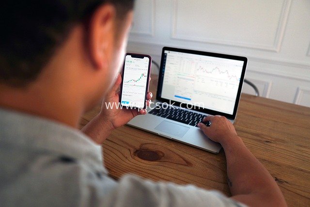 Investor Analyzing Stock Trading Data with Mobile Phone and Computer