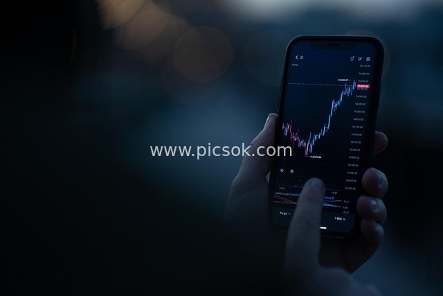 Checking Financial Candlestick Charts on a Mobile Phone at Night