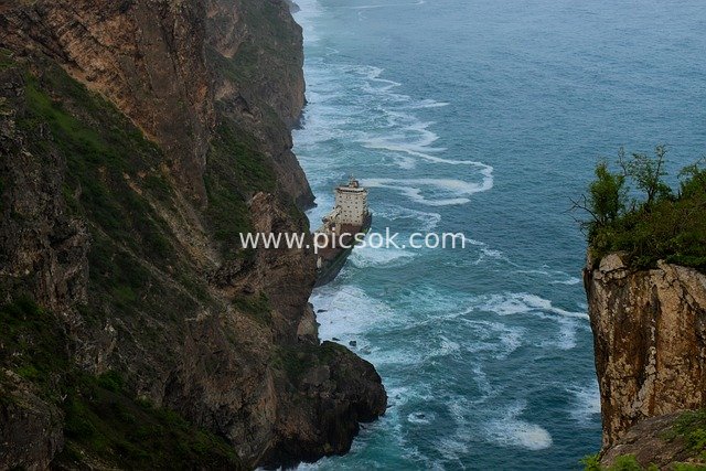 Blue Ocean and Abandoned Buildings at Coastal Cliffs
