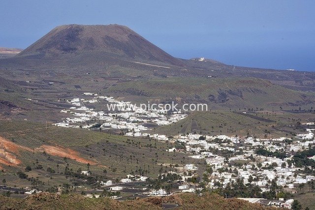 Panoramic Coastal View of a White Town at the Foot of a Volcano