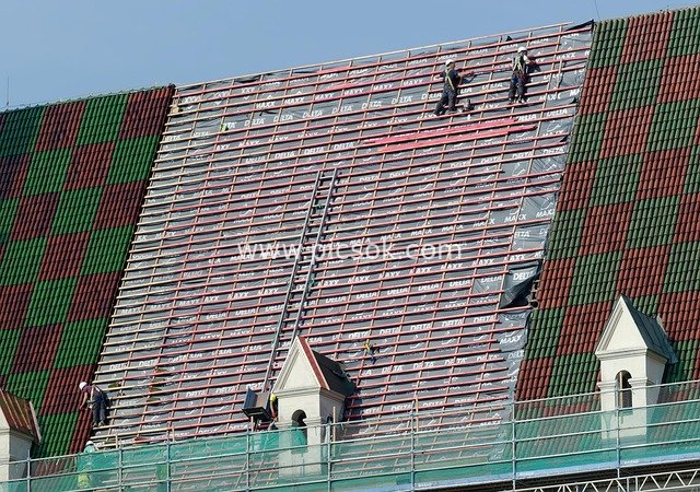 Roof Construction of Historic Building: Workers Installing Colorful Tiles