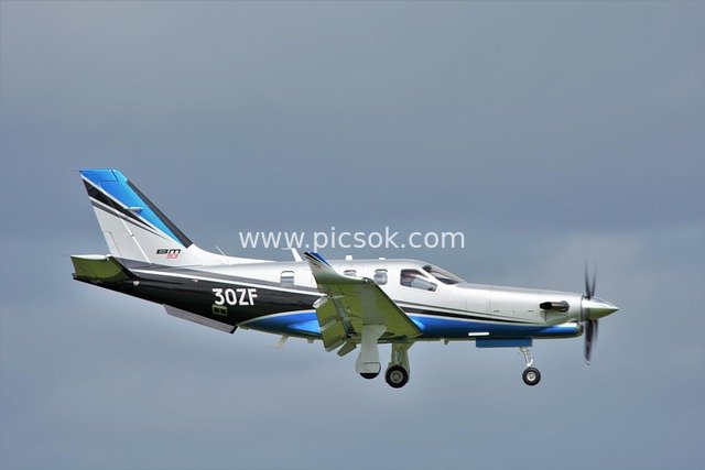 Silver-Blue Private Aircraft in Flight with Powerful Four-Bladed Propeller