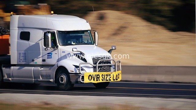 White Semi - Trailer Truck Traveling on Highway with Oversized Load