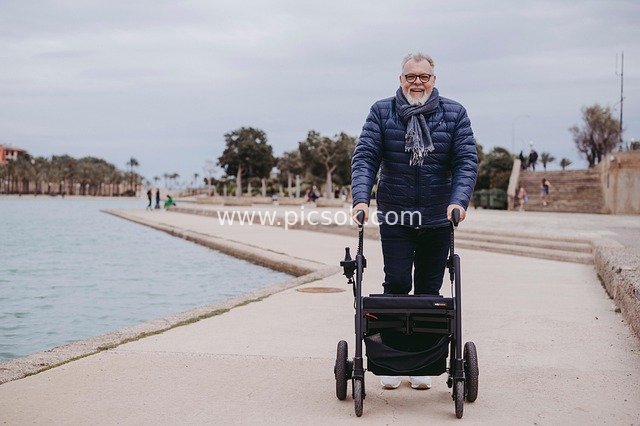 Elderly Man Walking Outdoors with a Walker in a Health Rehabilitation Scene
