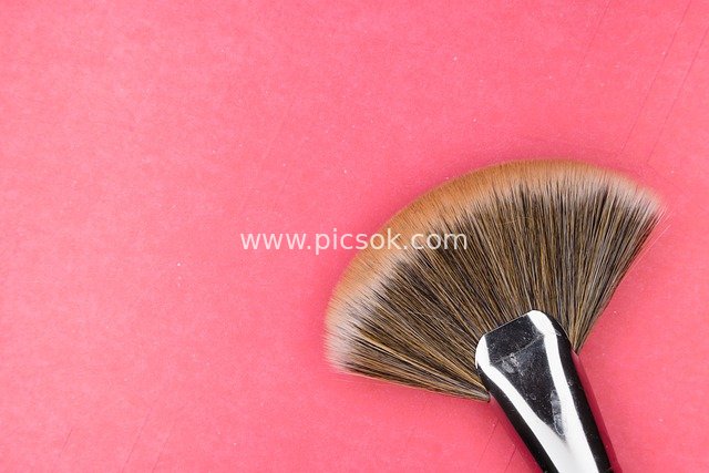 Fan-Shaped Makeup Brush on Pink Background - Close-Up of Professional Cosmetic Tool
