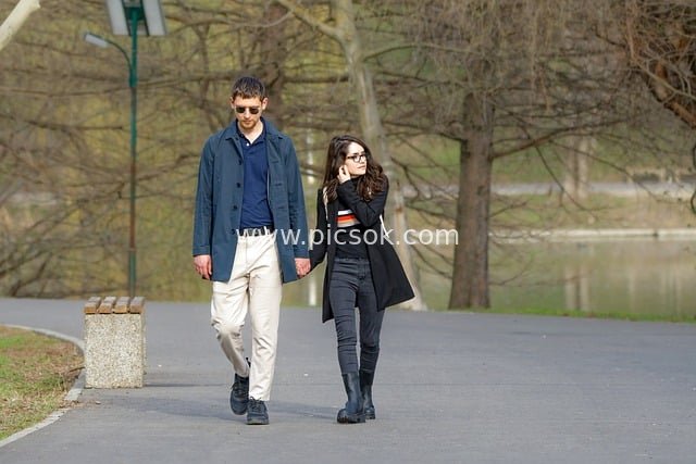 Couple Enjoying a Leisurely Stroll by the Lake in a Spring Park