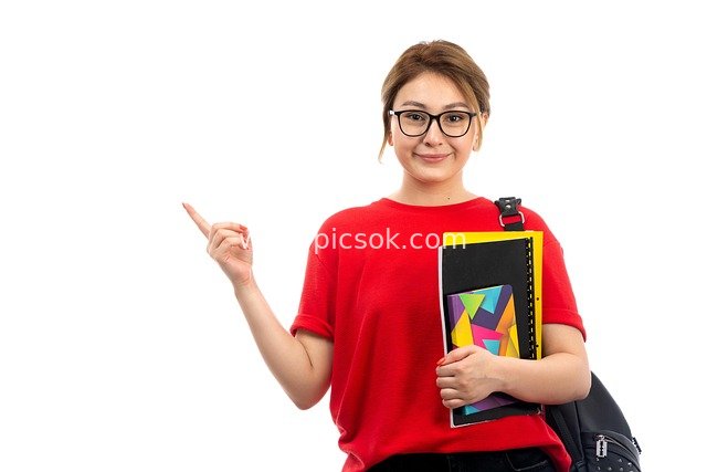 Smiling Female Student Holding Books Pointing Direction - Campus Educational Scene