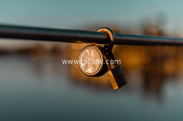 Close-up of Vintage Lock on Dock Railing by Sunset Lagoon