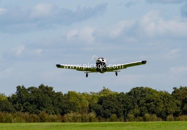 Small Plane Taking Off: Flight Scene Amid Blue Sky and Green Fields