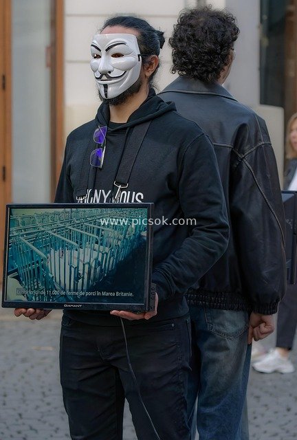 街头戴匿名面具男子持显示器 传递警示信息