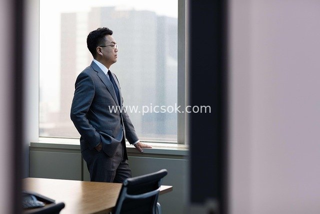 Corporate Executive Contemplating by Office Window – Business Scene Material