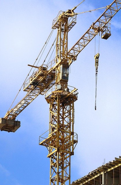 Tower Crane at Urban Construction Site | Engineering Equipment Against Clear Blue Sky