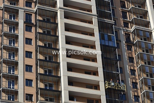 High-Rise Residential Construction, Workers Operating in Suspended Platforms, Urban Residential Complex Scene