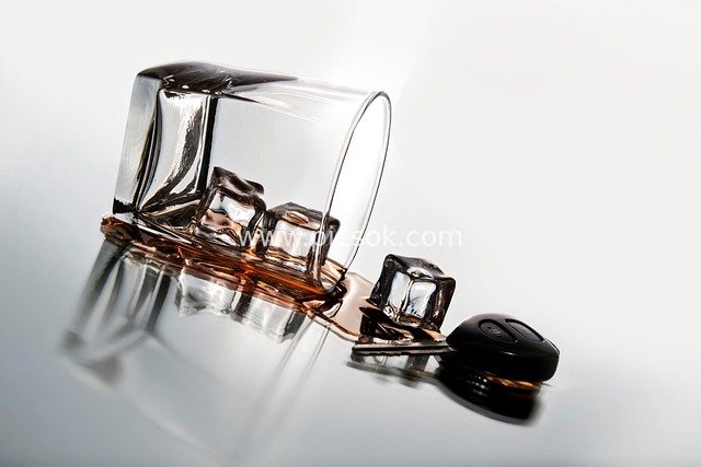 威士忌酒杯倾斜洒落冰与琥珀酒液