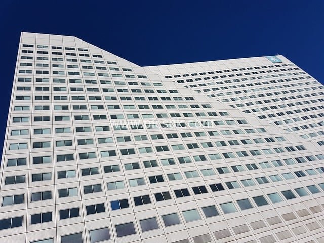 Modern White High-Rise Building: Urban Architectural Landscape Against Blue Sky