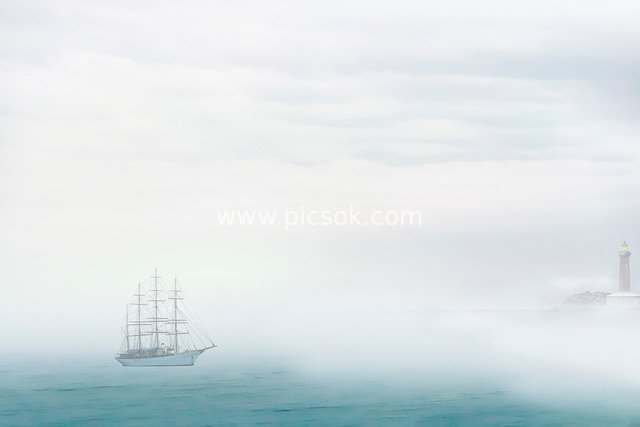 Foggy Ocean Landscape with Multi-Masted Sailing Ship and Seaside Lighthouse