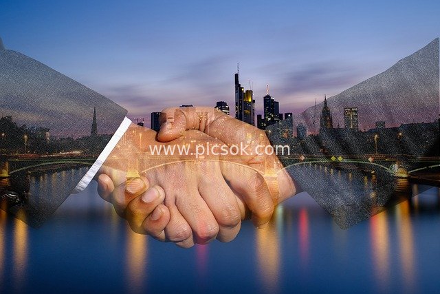 Double Exposure Image of Business Handshake Collaboration & Urban Skyline at Night