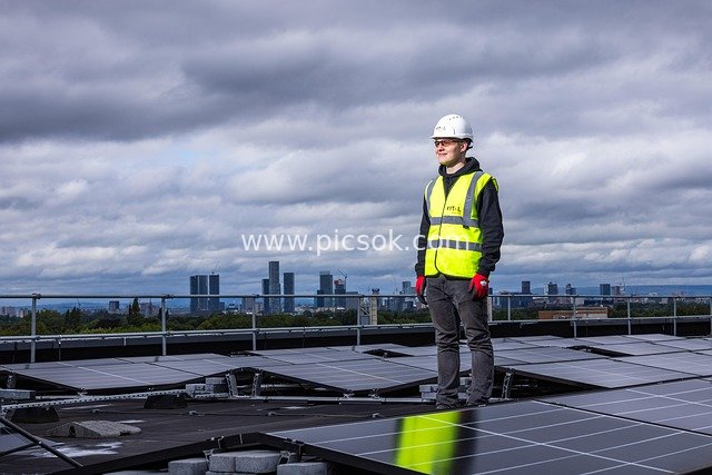 Solar Engineer at Work on Roof-Mounted Solar Panels