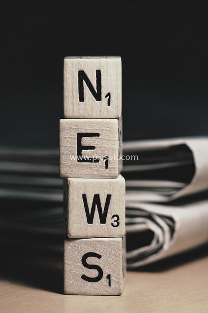 Wooden Letters Spelling NEWS with Newspaper Background - News Material Image