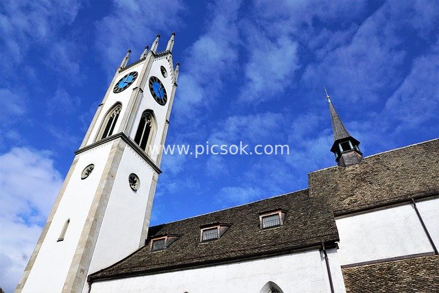 Swiss Küsnacht Church: Bell Tower View Against Blue Sky