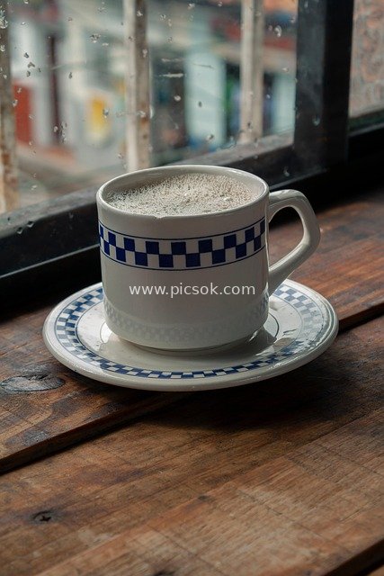 Close-up of a Hot Latte Cup Set on a Wooden Windowsill on a Rainy Day