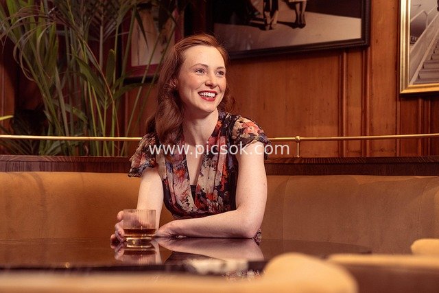 Smiling Woman Enjoying Drinks at a Cozy Bar/Restaurant Happy Hour