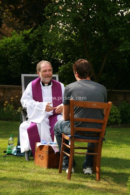 Priest Hearing Confession Outdoors: A Scene of Religious Forgiveness and Spiritual Dialogue