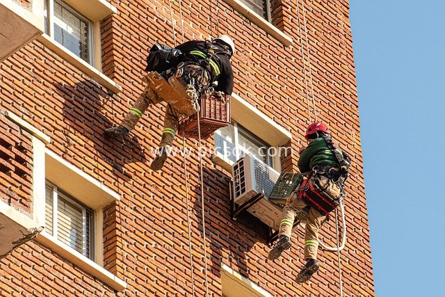 Rope Access Workers Performing High-Altitude Work on Red-Brick Building Facade