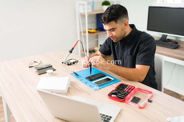 Professional Work Scene of a Technician Focused on Smartphone Repair