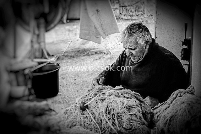 Greek Elderly Fisherman Mending Fishing Nets on a Boat - Black & White Documentary Photography