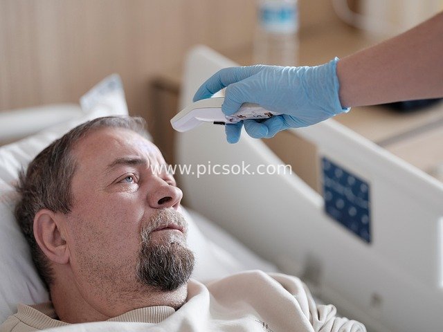 Hospital Scene: Medical Staff Taking Temperature of a Bedridden Patient